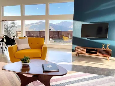 a living room with a yellow couch and a table at Eagle Rock Nest ～Quiet & Gorgeous Mountain Views in Three Rivers