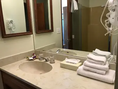 a bathroom with a sink and a mirror and towels at The River Inn in Three Rivers