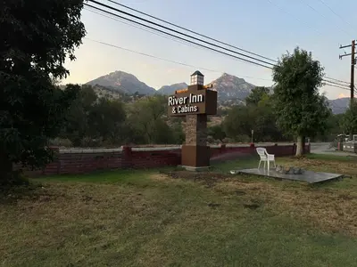 a sign for a hotel with mountains in the background at The River Inn in Three Rivers