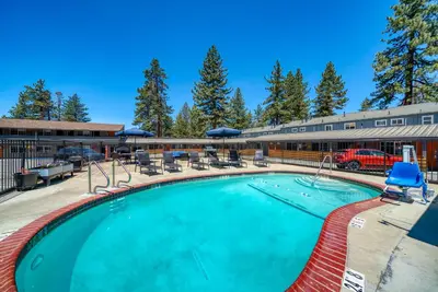 a large swimming pool with chairs and a building at Blue Jay Lodge in South Lake Tahoe