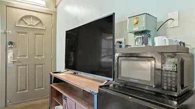 a kitchen with a microwave and a tv and a door at Blue Jay Lodge in South Lake Tahoe