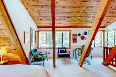 a bedroom with wooden ceilings and chairs and a bed at The Regal Bear in Homewood