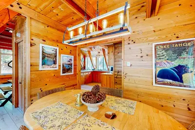 a dining room with a table in a wooden cabin at The Regal Bear in Homewood