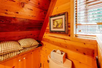 a log cabin bedroom with a bed and a window at The Regal Bear in Homewood