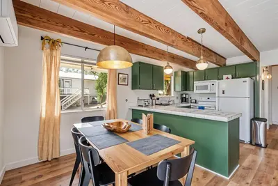a kitchen and dining room with green cabinets and a wooden table at Marina Beach Cabin - Dog-Friendly Home with Deck! home in Groveland