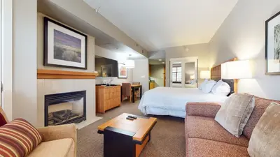 a hotel room with a bed and a fireplace at Village Monache #309 condo in Mammoth Lakes