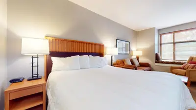 a bedroom with a large white bed and a couch at Village Monache #309 condo in Mammoth Lakes