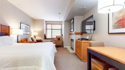 a hotel room with a bed and a living room at Village Monache #309 condo in Mammoth Lakes