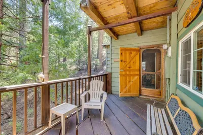 a porch with two chairs and a wooden door at Creekside Cabin By Calaveras Big Trees State Park in Camp Connell
