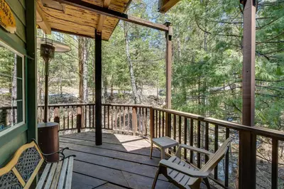 a porch with two chairs and a bench on it at Creekside Cabin By Calaveras Big Trees State Park in Camp Connell