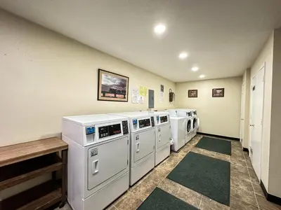 a laundry room with three washing machines and a table at La Vista Blanc #16 condo in Mammoth Lakes
