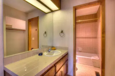 a bathroom with a sink and a mirror and a tub at Ski Lake Lodge home in Incline Village