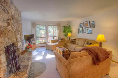 a living room with couches and a stone fireplace at Ski Lake Lodge home in Incline Village
