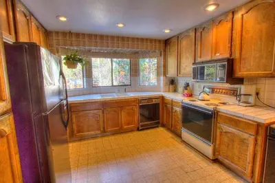 a kitchen with wooden cabinets and a stainless steel refrigerator at Ski Lake Lodge home in Incline Village