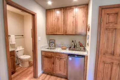 a small kitchen with wooden cabinets and a dishwasher at Cozy Bear Lodge home in Incline Village