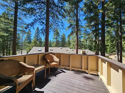 a deck with chairs and a view of trees at Cozy Bear Lodge home in Incline Village
