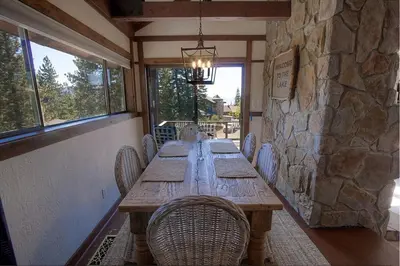 a long wooden table with chairs and a stone wall at Inclining View home in Incline Village
