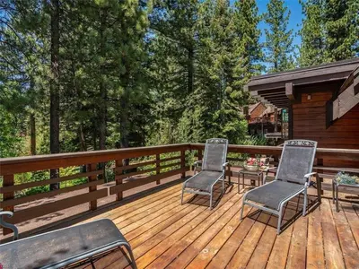 two chairs and a table on a wooden deck at Third Creek Comfort townhouse in Incline Village
