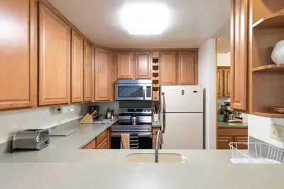 a kitchen with wooden cabinets and a white refrigerator at 2BR Townhome Walk to Beach or Trails in Carnelian Bay