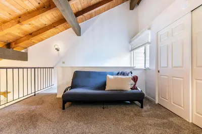 a blue couch in a room with a wooden ceiling at 2BR Townhome Walk to Beach or Trails in Carnelian Bay