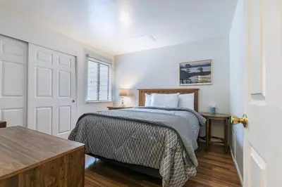 a white bedroom with a bed and a table at 2BR Townhome Walk to Beach or Trails in Carnelian Bay