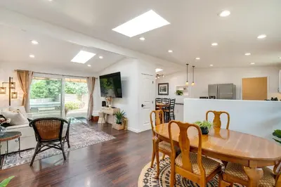 a kitchen and living room with a wooden table and chairs at Modern Meadow Vista Vacation Home with Spacious Deck in Meadow Vista