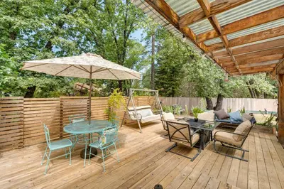 a patio with a table and chairs and an umbrella at Modern Meadow Vista Vacation Home with Spacious Deck in Meadow Vista