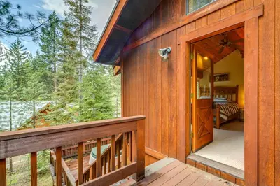 a wooden house with a balcony and a bedroom at Deck with Hot Tub Serene Cabin in Truckee in Truckee