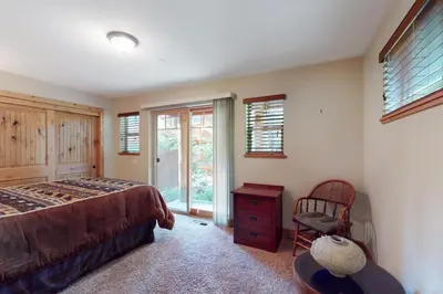 a bedroom with a bed and a chair and a window at Kings Beach Retreat in Kings Beach