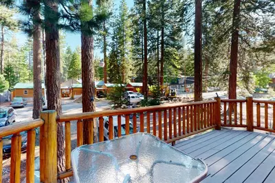 a wooden deck with a bench on a porch with trees at Kings Beach Retreat in Kings Beach