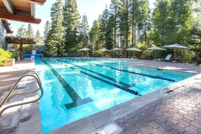 a large swimming pool with blue water at Bright 2BDR Next to NorthStar - 5min Walk! in Truckee