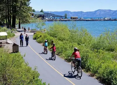 a group of people riding bikes on a path by the water at Bright 2BDR Next to NorthStar - 5min Walk! in Truckee