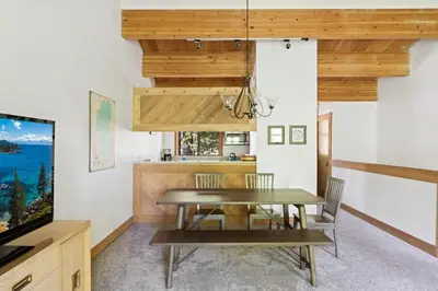 a dining room with a table and a television at Bright 2BDR Next to NorthStar - 5min Walk! in Truckee