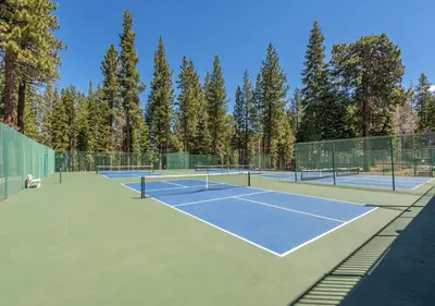a couple of tennis courts with trees in the background at Northstar Resort True Ski In Ski Out Year-Round Hot Tubs Book on Your Mobile for Promo Price in Truckee