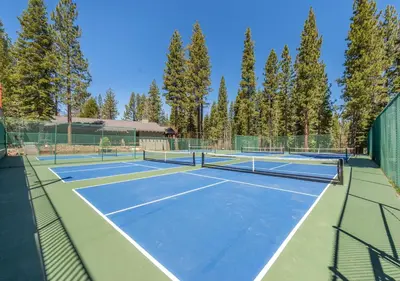 a couple of tennis courts with trees in the background at Northstar Resort True Ski In Ski Out Year-Round Hot Tubs Book on Your Mobile for Promo Price in Truckee