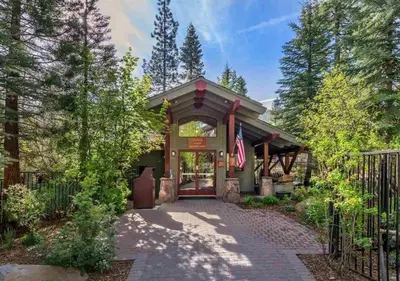 a house with a flag in front of a gate at Northstar Resort True Ski In Ski Out Year-Round Hot Tubs Book on Your Mobile for Promo Price in Truckee