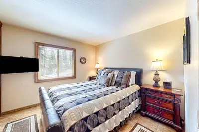 a bedroom with a bed and a dresser and a window at Powder Pines Retreat in Kingswood Estates
