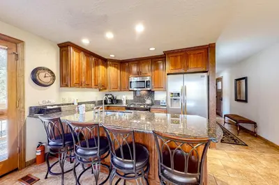 a kitchen with a counter with bar stools at Powder Pines Retreat in Kingswood Estates