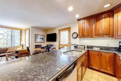 a kitchen with a sink and a living room at Powder Pines Retreat in Kingswood Estates