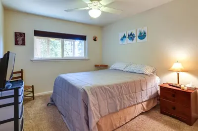 a bedroom with a bed and a tv and a window at Cozy Mi-Wuk Village Cabin with Deck! in Mi-Wuk Village