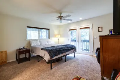 a bedroom with a bed and a ceiling fan at Cozy Mi-Wuk Village Cabin with Deck! in Mi-Wuk Village