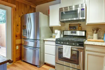 a kitchen with a stainless steel refrigerator and microwave at Fire Pit, Deck and Grill Cozy Twain Harte Cabin! in Twain Harte