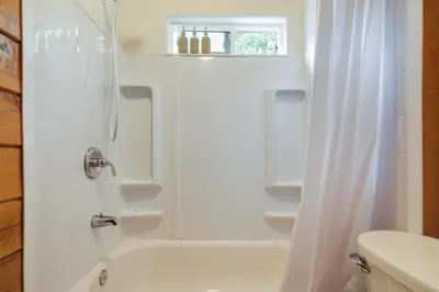 a white bathroom with a shower and a sink at Fire Pit, Deck and Grill Cozy Twain Harte Cabin! in Twain Harte