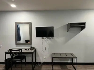 a room with a table and a tv on a wall at Travel Inn Gilroy in Gilroy