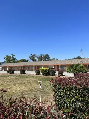 a building with a lot of plants in front of it at Travel Inn Gilroy in Gilroy