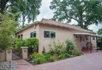 a house with a gate and flowers in front of it at Sequoia Basecamp with Hot Tub Oasis in Visalia