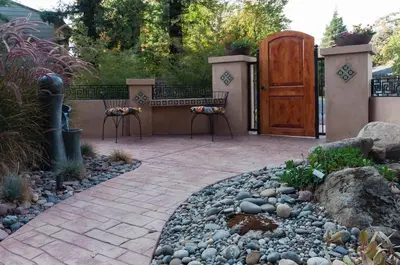 a patio with a bench and a wooden door at Sequoia Basecamp with Hot Tub Oasis in Visalia