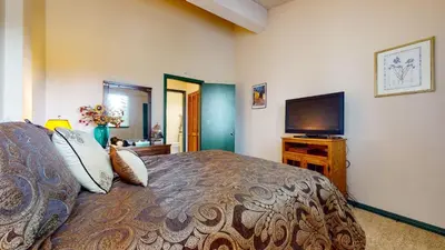 a bedroom with a bed and a flat screen tv at Summit #232 condo in Mammoth Lakes