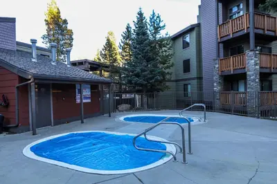 a small swimming pool in a courtyard next to a building at Summit #232 condo in Mammoth Lakes