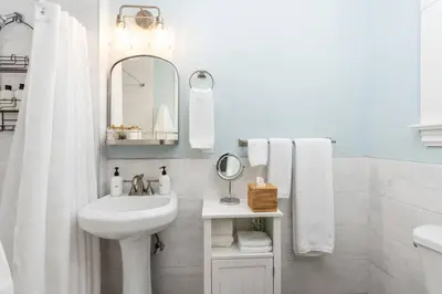 a white bathroom with a sink and a mirror at Grape Escape Inn & Suites in Lodi